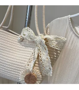 Close-up of woven tote bag with lace bow, pearl buckle and sunflower charm detail