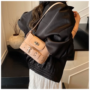 Détail d'un sac seau rose avec fermoir rotatif argenté et bandoulière à œillets métalliques