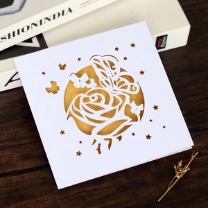 Détail de carte de mariage découpée au laser avec motifs de roses et papillons ciselés