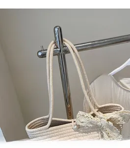 Detailed close-up of woven tote bag strap with lace bow and pearl buckle detail