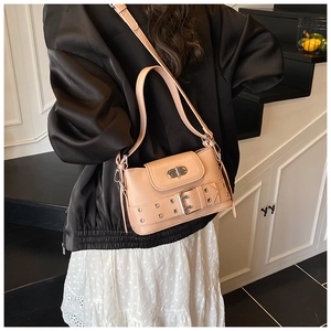 Détail d'un sac à main rose en cuir avec boucle métallique et fermoir tournant