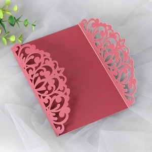 Detail of dark red laser-cut wedding invitation with intricate floral filigree pattern