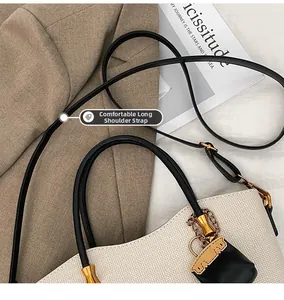 Detail of cream woven tote bag with contrast black leather straps and gold hardware