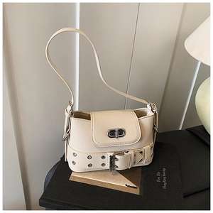 Vue détaillée du sac seau crème avec fermoir rotatif argenté et garniture à œillets