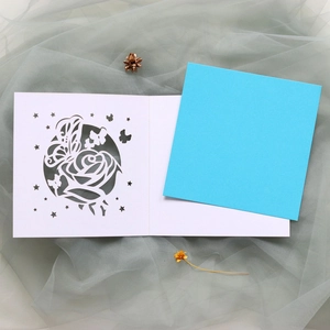 Détail de motifs de roses et papillons découpés au laser sur une carte d'invitation mariage