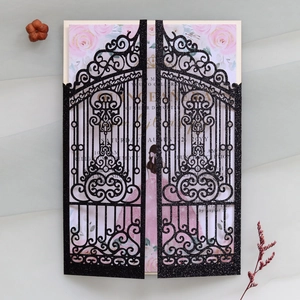 Intricate laser-cut gate design on black glitter invitation with floral inner card