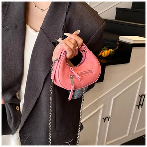 Detail of pink micro hobo bag in lychee leather with silver chain and long fringe zipper