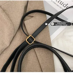 Detail of adjustable black leather strap with premium gold metal buckle on tote bag