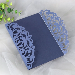 Detail of laser-cut navy blue pearlescent paper wedding invitation with floral patterns