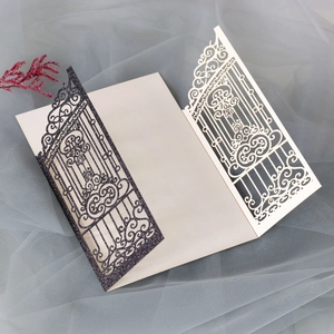 Close-up of laser-cut gate design on glitter wedding card with dried flower detail