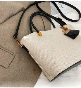 Detail view of woven texture with black leather trim and golden metal hardware