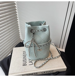 Detail der hellblauen gesteppten Beuteltasche mit Silberkette und Perlen-Schleifenanhänger