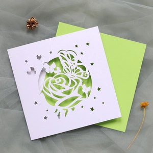 Détails de motifs de roses et papillons découpés au laser sur carte d'invitation