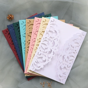 Detail of laser-cut floral wedding invitation covers in various elegant pearlescent colors