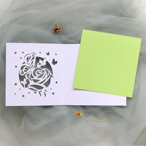 Détail de la carte de vœux ajourée avec rose et papillon découpés au laser et page verte