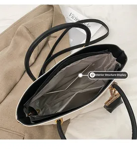 Detailed view of the interior compartments and zipper pocket of the black tote bag