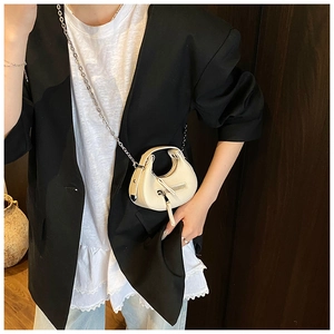 Detail of cream lychee leather mini half-moon bag with silver chain on model