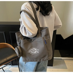 Détail du cabas en toile gris foncé avec poche latérale et petit porte-monnaie à clip