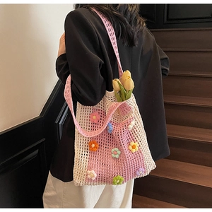 Détail d'un sac cabas en crochet fait main rose avec broderies de fleurs 3D colorées