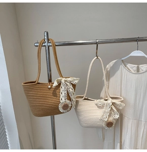 Detail of hand-woven straw tote with lace bow and pearl sunflower charm in dual colors