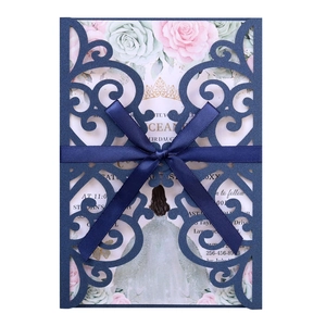 Λεπτομέρεια προσκλητηρίου γάμου laser-cut με μπλε σχέδιο και κομψό φιόγκο κορδέλας