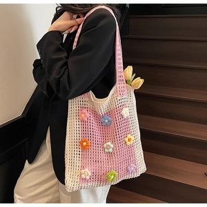 Détail d'un sac au crochet fait main avec fleurs 3D colorées et poignée rose élégante