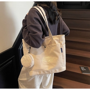 Détail du sac cabas en toile crème avec broderie et petite pochette ronde zippée