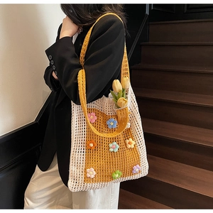 Détail d'un sac cabas au crochet fait main avec fleurs 3D colorées et bandoulière jaune