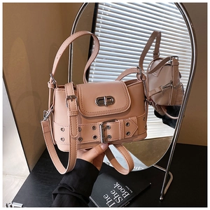 Détail du sac seau rose nude avec ceinture en cuir, œillets en métal et fermoir rotatif