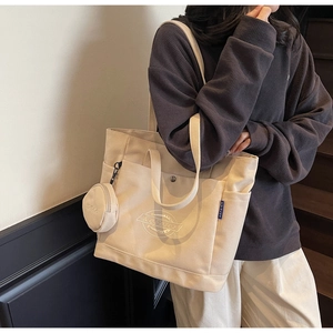 Vue détaillée du grand sac cabas en toile avec poches avant et logo brodé chic