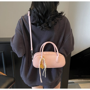 Detail view of pink litchi grain shoulder bag worn by model in a daily lifestyle scene
