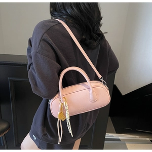 Pink lychee texture Boston bag with adjustable shoulder strap shown on a model
