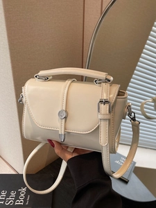 Minimalist beige small square handbag with silver metal buckle and adjustable strap