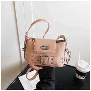 Détail macro d'un sac seau rose clair avec boucle de ceinture argentée et fermoir métal