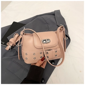 Détail d'un sac seau en cuir rose avec boucle en métal argenté et sangle à œillets décorative