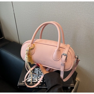 Close-up of pink lychee grain leather boston bag with gold hardware and silk scarf detail