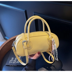 Detail of yellow lychee texture boston bag with dual handles and woven rope accessory