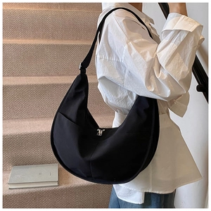 Detail showing high-density nylon fabric and side functional pocket of the black moon bag