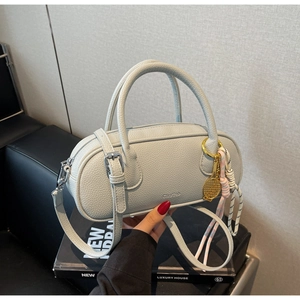 Detail of lychee pattern leather bowling bag with tennis racket charm held by hand