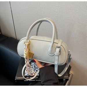 Detail of light grey lychee leather handbag with silk scarf and gold hardware accessories