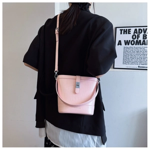 Pink croc-embossed bucket bag detail with silver turn-lock and slim shoulder strap