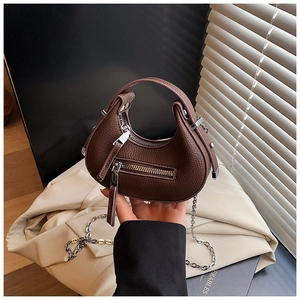 Detail of a brown lychee pattern crescent bag with silver hardware and metal chain strap