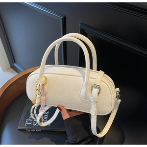 Close-up of white lychee leather texture and silver hardware on a Boston handbag