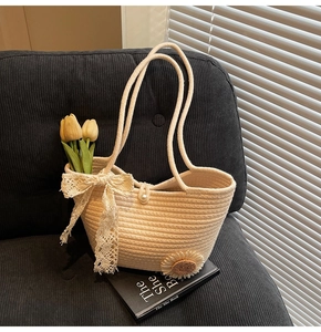Close-up of woven tote bag featuring delicate lace bows, pearls and daisy decorations