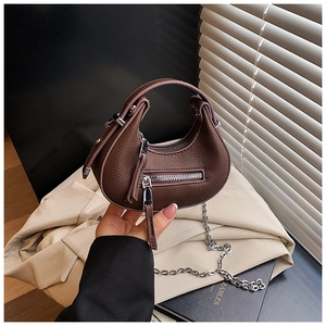 Close-up of brown litchi pattern leather mini bag with silver chain and decorative zipper