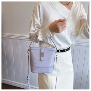 Détail du sac seau lilas à motif crocodile avec fermoir métallique et poignée fixe
