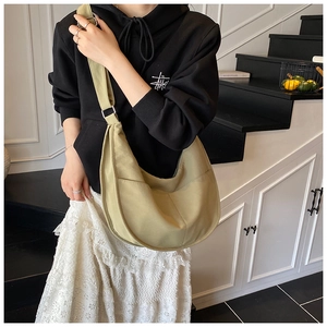 Detailed view of casual olive green hobo canvas crossbody bag with dual front pockets