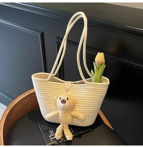 Detailed texture of off-white hand-woven tote bag with pearl button and cute plush bear