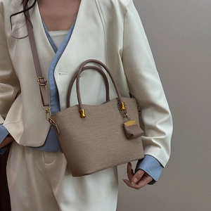 Detail of woven texture on the brown tote bag with golden hardware and accessories