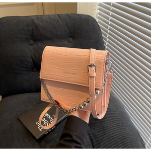 Pink croc-embossed crossbody bag with silver chain handle and pearl bead accents